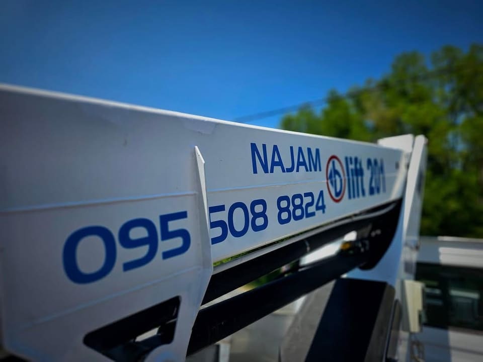 Detalj ruke autokošare s natpisom Najam i brojem telefona