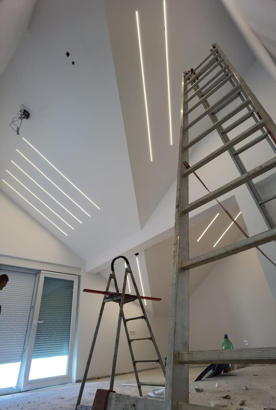 Linijska LED rasvjeta ugrađena u kosi strop potkrovlja tijekom završnih radova